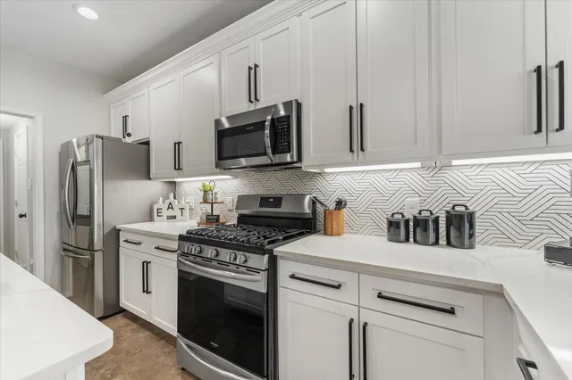 a kitchen with stainless steel appliances a refrigerator stove and microwave