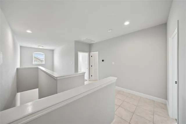 a hallway with white walls and tiles