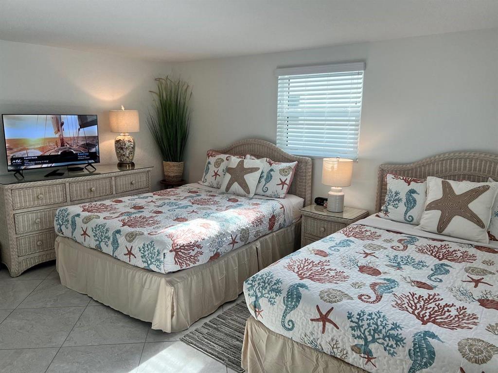 6154 Midnight Pass Road, Unit A04 Sarasota, FL 34242 - Photo 11 of 15 a bedroom with two beds and a flat screen tv
