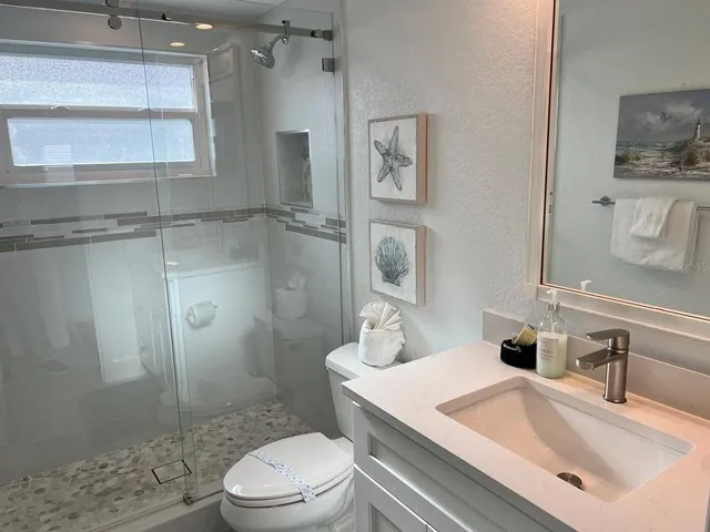 a bathroom with a sink a toilet and shower