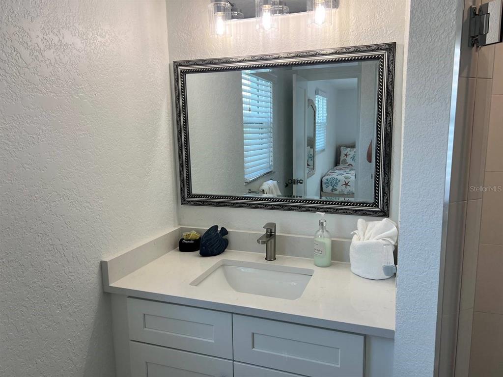 6154 Midnight Pass Road, Unit A04 Sarasota, FL 34242 - Photo 13 of 15 a bathroom with a sink and a mirror