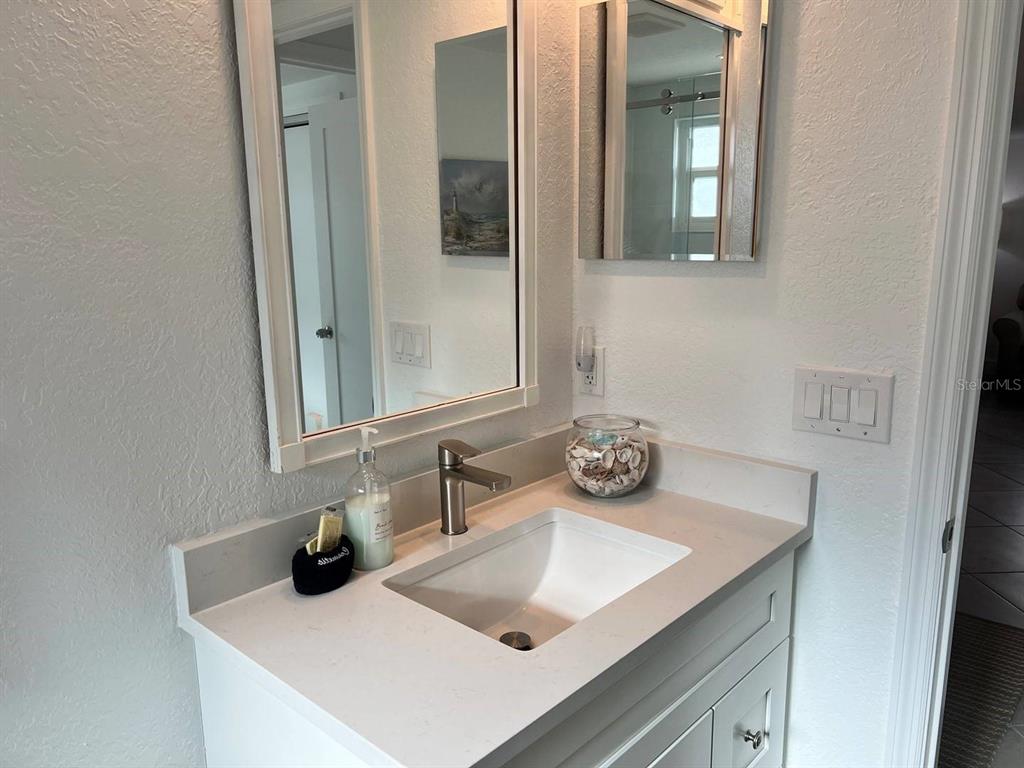 6154 Midnight Pass Road, Unit A04 Sarasota, FL 34242 - Photo 14 of 15 a bathroom with a sink and a mirror