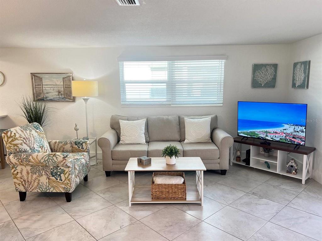 6154 Midnight Pass Road, Unit A04 Sarasota, FL 34242 - Photo 2 of 15 a living room with furniture a rug and a window