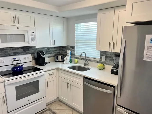 a kitchen with stainless steel appliances white cabinets and a sink