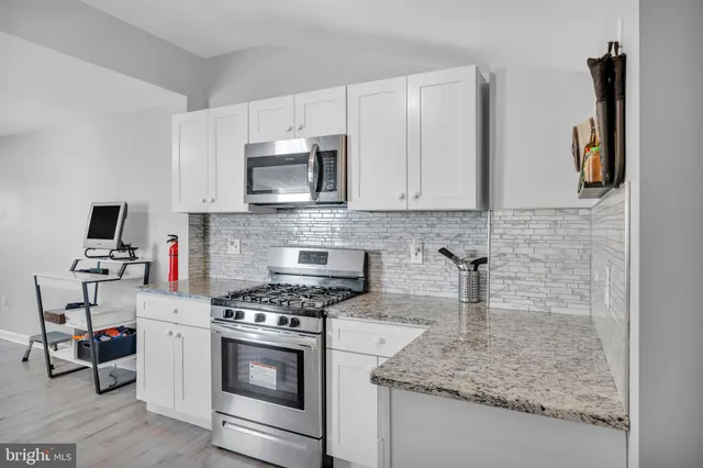a kitchen with stainless steel appliances granite countertop a sink stove and microwave