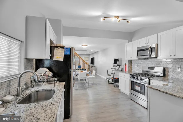 a kitchen with stainless steel appliances granite countertop a sink stove and refrigerator