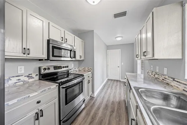 a kitchen with granite countertop stainless steel appliances and cabinets