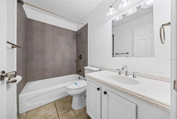 a bathroom with a sink a toilet a mirror a bathtub and shower