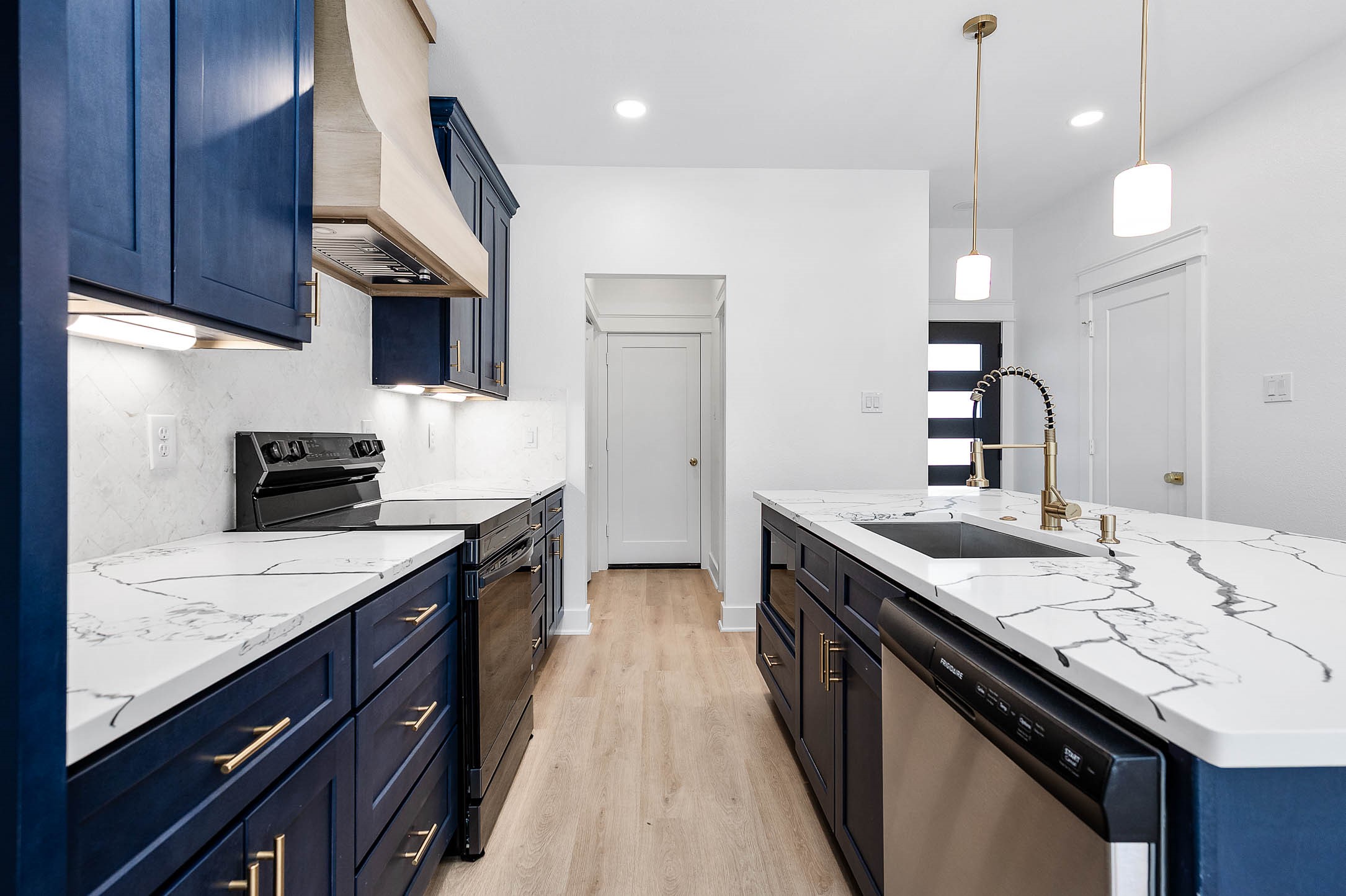 8602 Hoffman Street Houston, TX 77016 - Photo 3 of 30 Galley-style layout highlighting sleek finishes, under-cabinet lighting, and a clean, functional design.