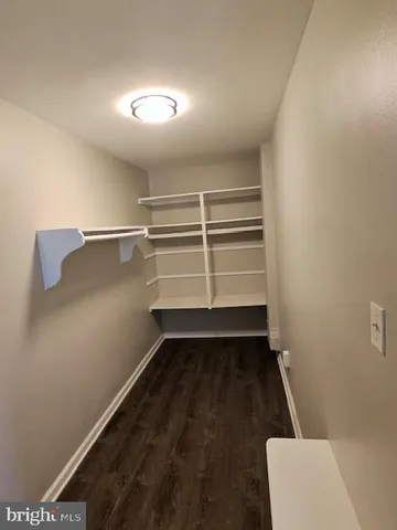 a view of walk in closet with empty racks