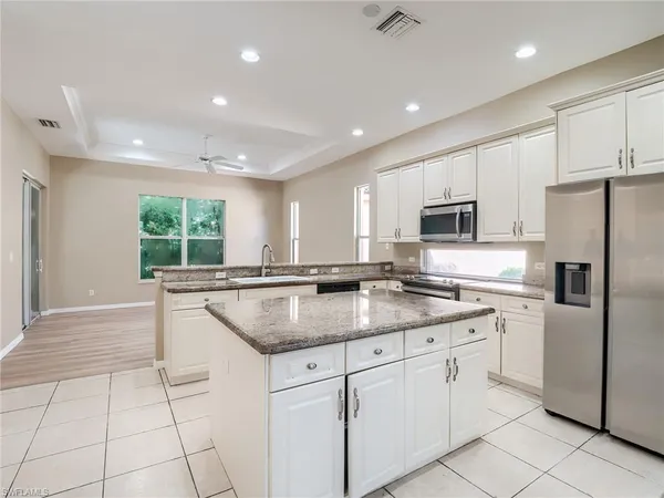 a kitchen with stainless steel appliances granite countertop a sink and white cabinets
