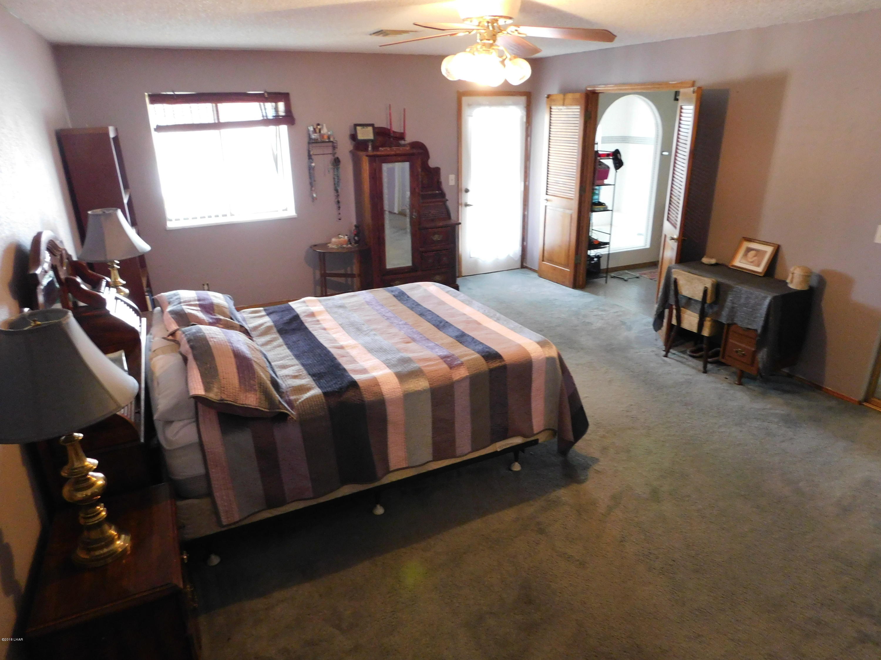 4010 Bluegrass Drive, Unit R Lake Havasu City, AZ 86406 - Photo 22 of 47 a spacious bedroom with a bed a dresser and mirror