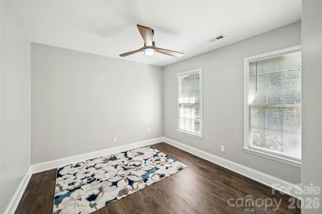 a view of wooden floor in an empty room with a window