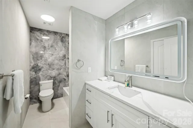 a bathroom with a double vanity sink mirror and toilet
