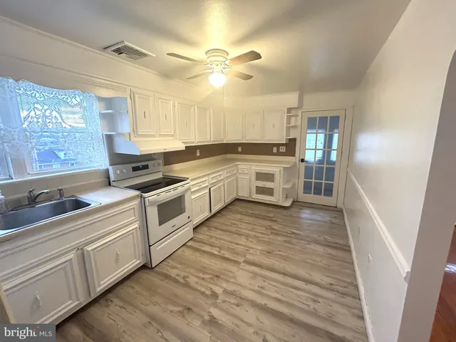 a kitchen with white cabinets and white appliances