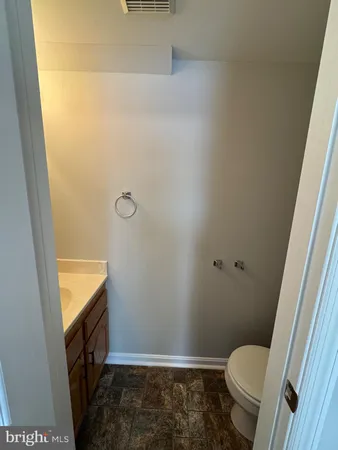 a bathroom with a granite countertop toilet and a shower