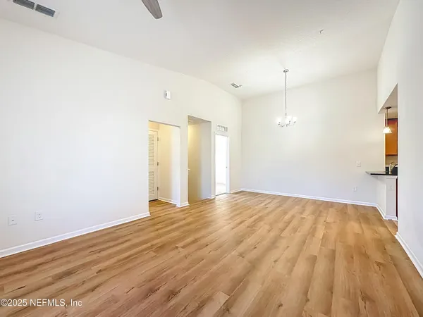 a view of empty room with wooden floor