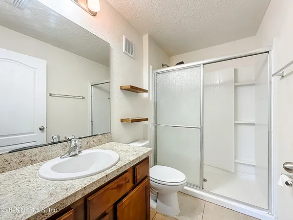 a bathroom with a granite countertop sink toilet and shower