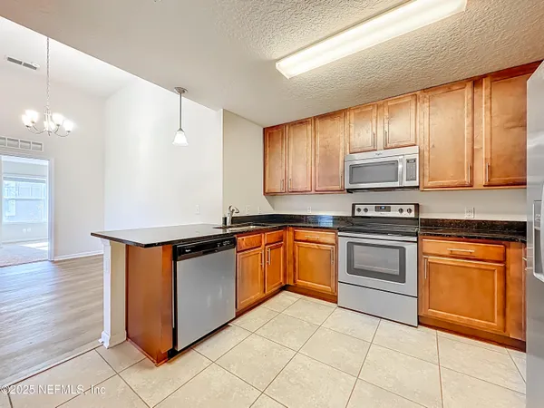 a kitchen with stainless steel appliances granite countertop a stove a sink and a refrigerator