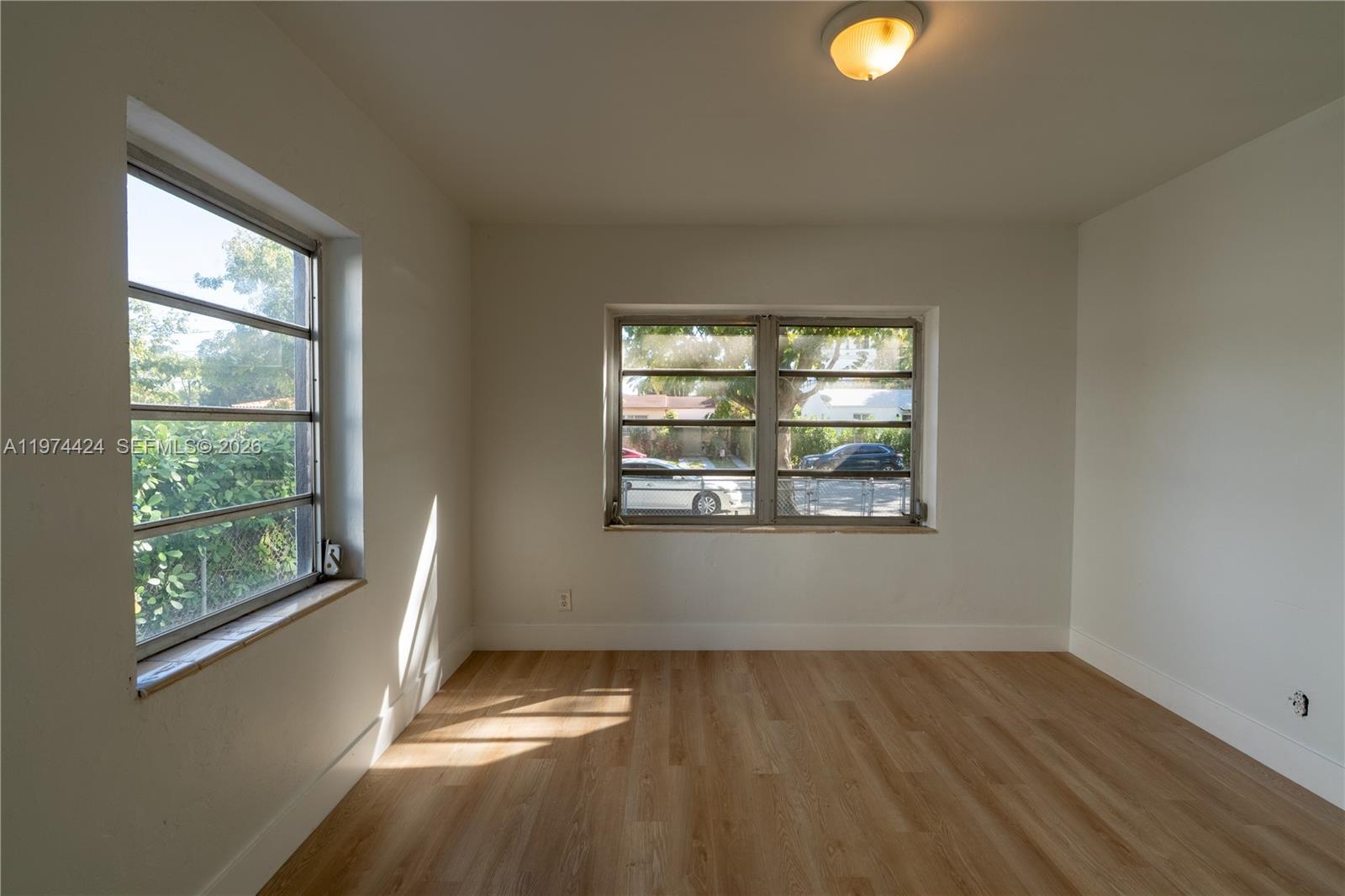 3665 Southwest 16th Street, Unit 3665 Miami, FL 33145 - Photo 13 of 25 an empty room with wooden floor and windows