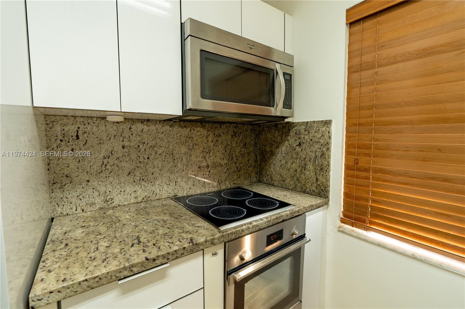 3665 Southwest 16th Street, Unit 3665 Miami, FL 33145 - Photo 20 of 25 a kitchen with granite countertop white cabinets and stainless steel appliances