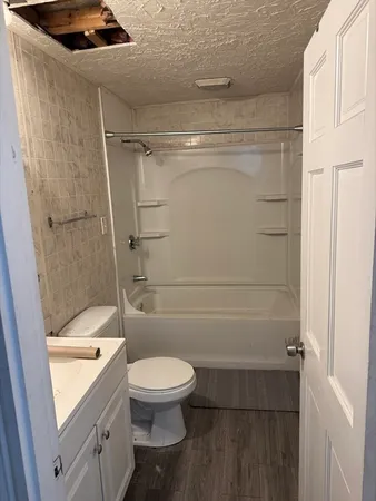 a bathroom with a shower a toilet and a sink