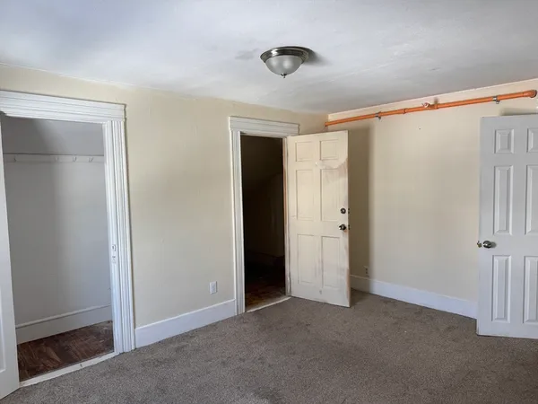 a view of a small space with wooden floor and a window