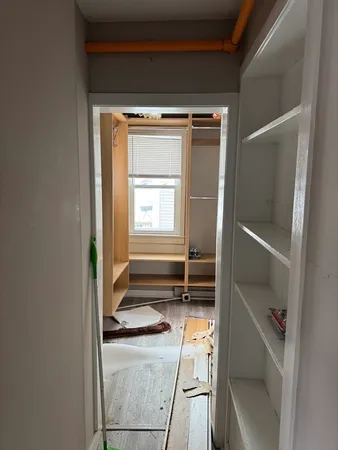 a view of walk in closet with empty racks