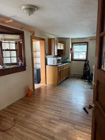 a view of a kitchen with furniture and wooden floor