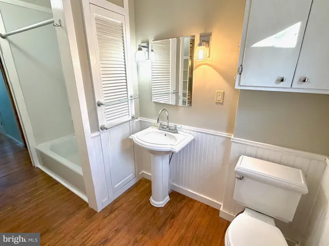 a bathroom with a sink toilet and a mirror