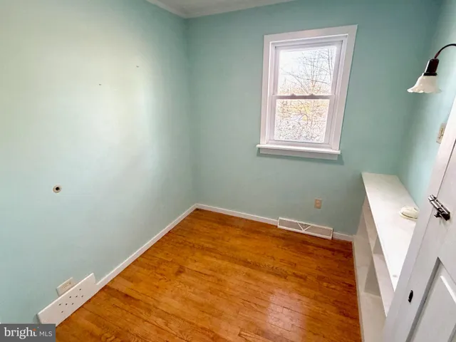 a view of a room with wooden floor and a window