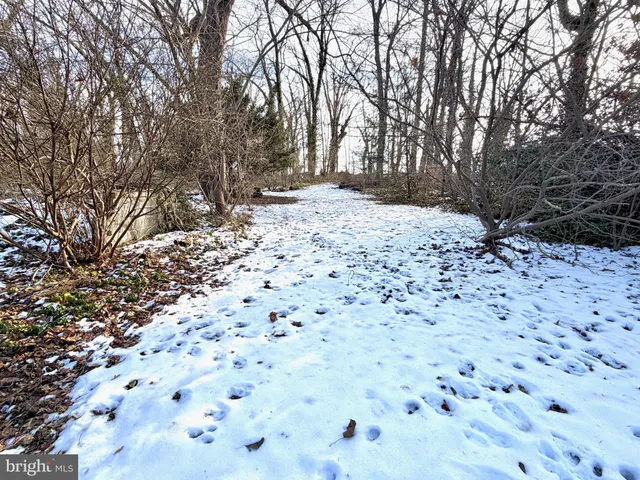 a view of a yard covered with snow in front of house