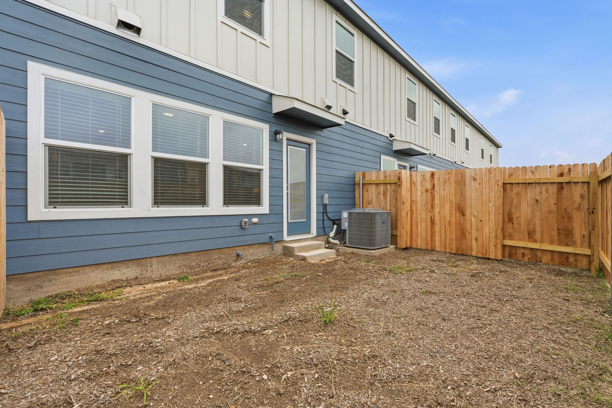 164 Cinnabar Lane, Unit 2 Kyle, TX 78640 - Photo 21 of 21 Private backyard space featuring a new wood privacy fence, a concrete patio, and blue horizontal siding