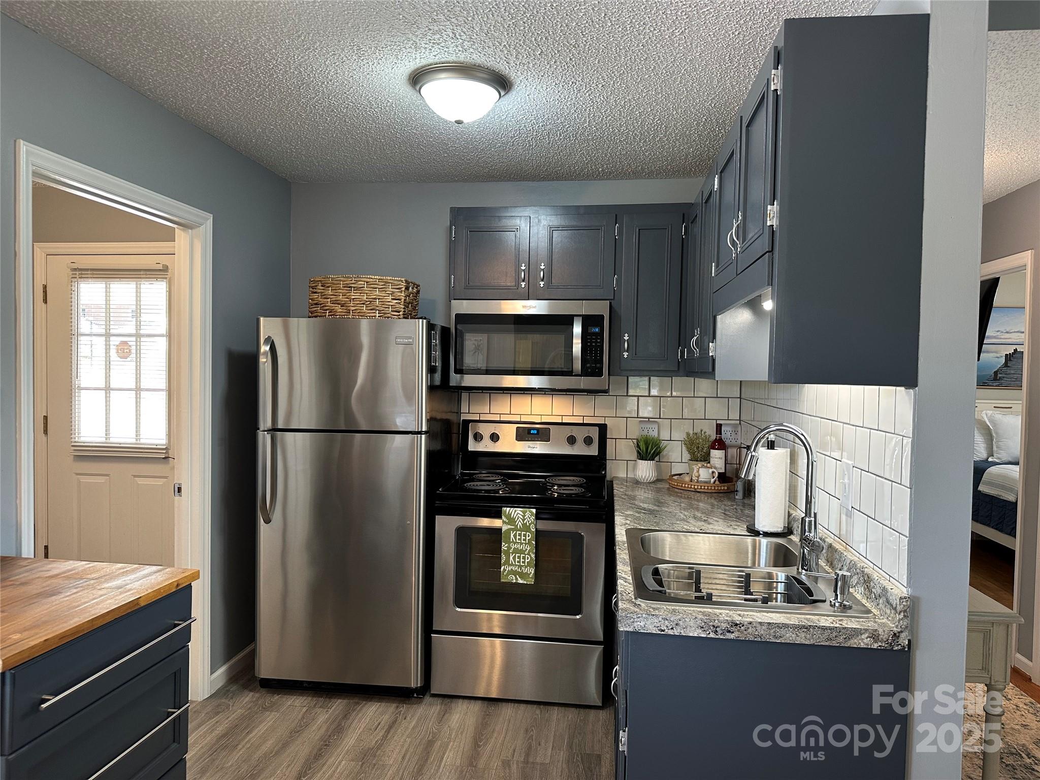 102 Stephens Drive Morganton, NC 28655 - Photo 13 of 48 a kitchen with stainless steel appliances granite countertop a refrigerator stove and microwave