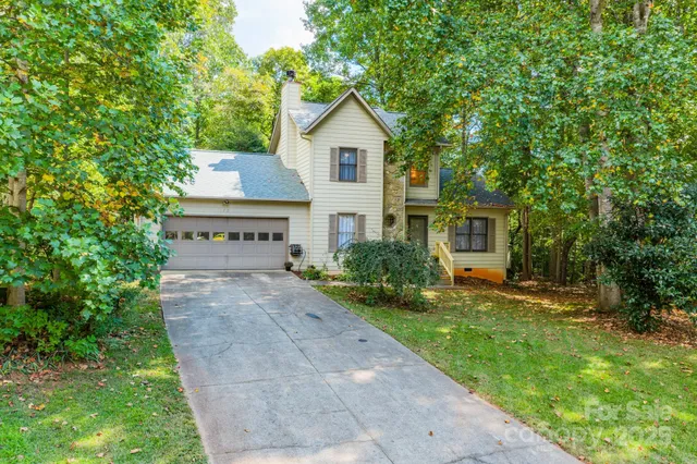 a front view of a house with a yard and trees