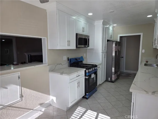 a kitchen with stainless steel appliances granite countertop a stove a sink and a refrigerator