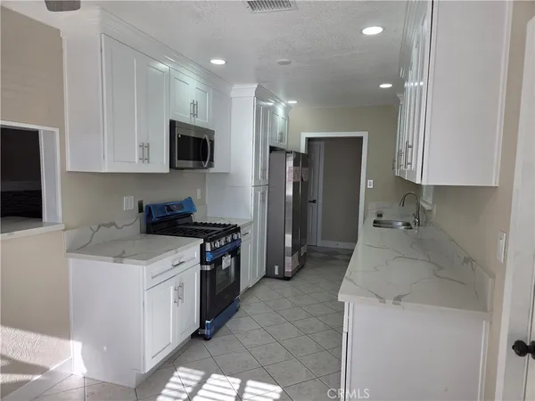 a kitchen with a sink stove and refrigerator
