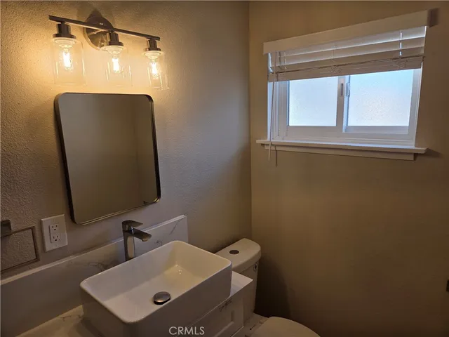 a bathroom with a sink a toilet and a mirror