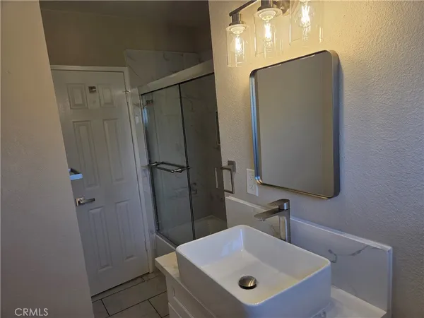 a bathroom with a sink a mirror and shower