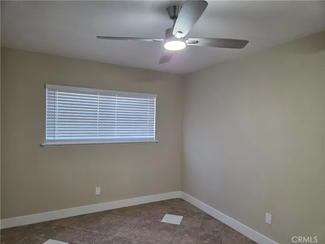 an empty room with a window and a fan