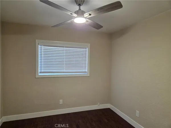 an empty room with a window and a fan