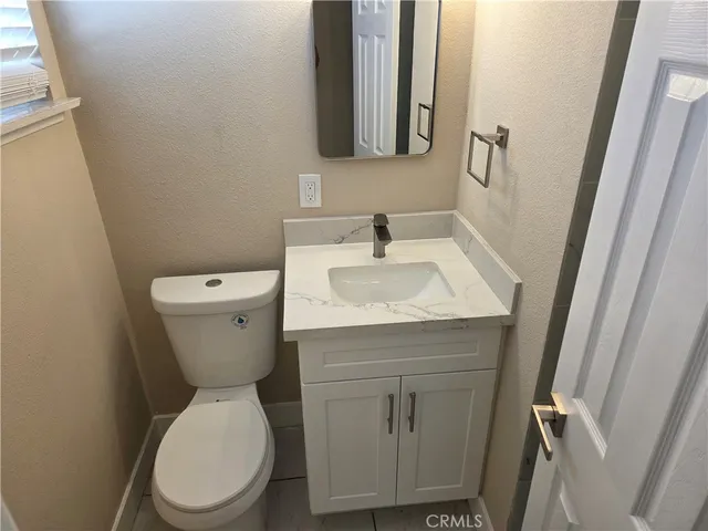 a bathroom with a sink and mirror with toilet
