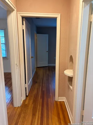 a view of a hallway with wooden floor and staircase