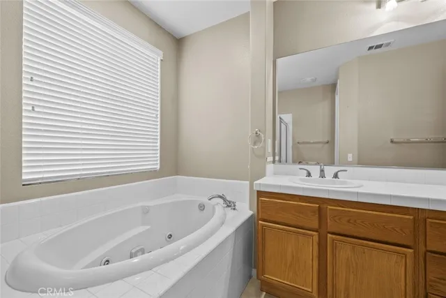 a bathroom with a tub sink and mirror