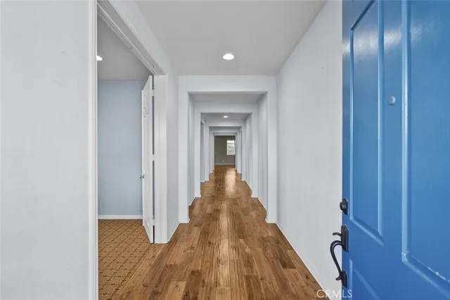 a view of a hallway with wooden floor and entryway