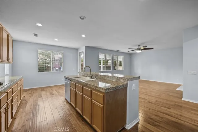 a kitchen with kitchen island granite countertop a sink and wooden floors