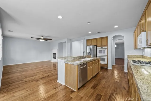 a kitchen with stainless steel appliances granite countertop a stove and a wooden floors