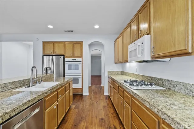 a kitchen with stainless steel appliances granite countertop a sink and stove top oven