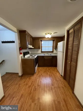 a kitchen with wooden floors and stainless steel appliances