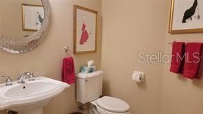 650 Golden Gate Point, Unit 301 Sarasota, FL 34236 - Photo 26 of 31 a bathroom with a sink vanity mirror and toilet
